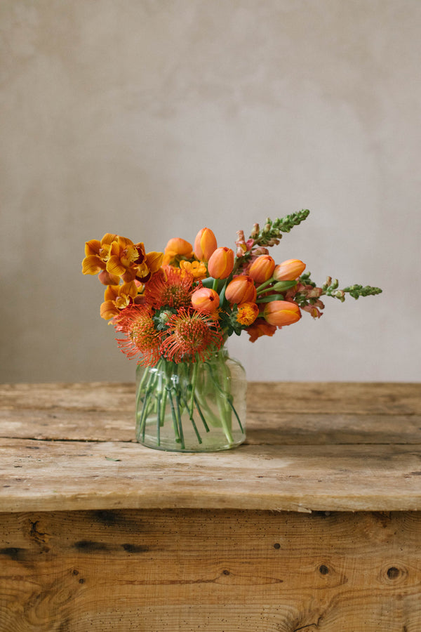Jarrón con flores naranjas