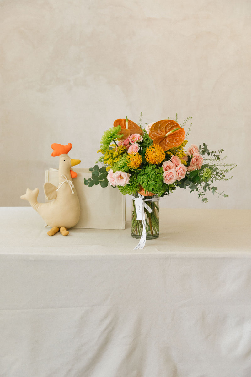 Jarrón duotono de flores naranjas y rosas