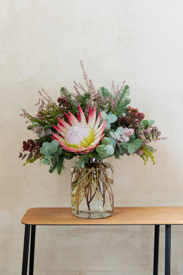 Centro en jarrón con flores rosas. Protea Cyneroides